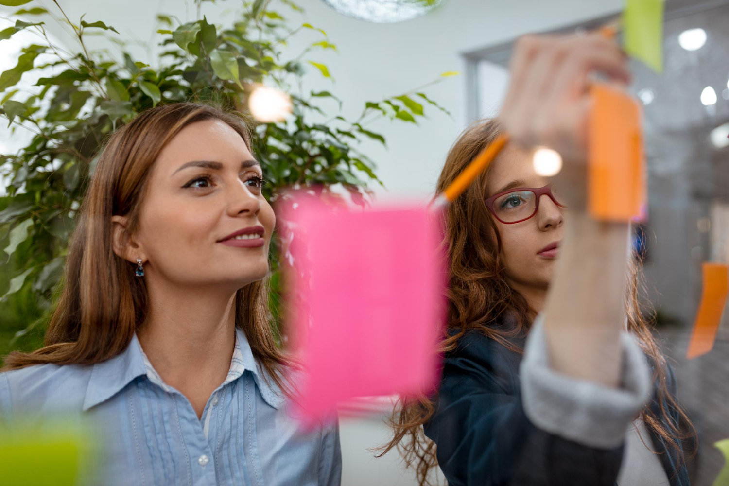 Duas mulheres sorrindo e fazendo anotações sobre o que é Branding
