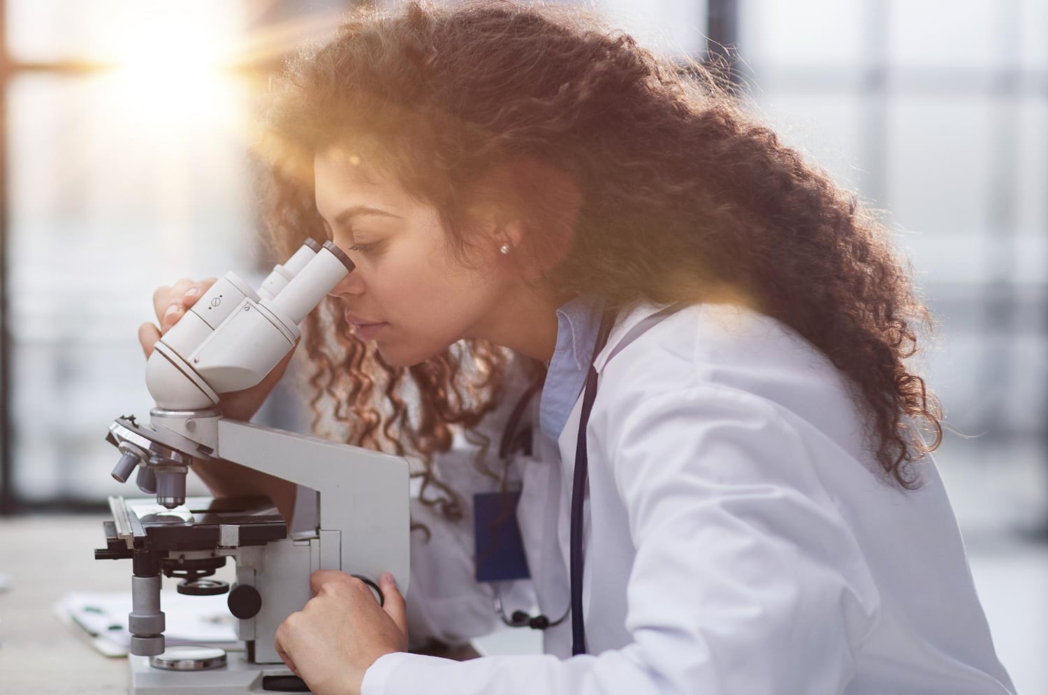 Biomédica olhando um microscópio
