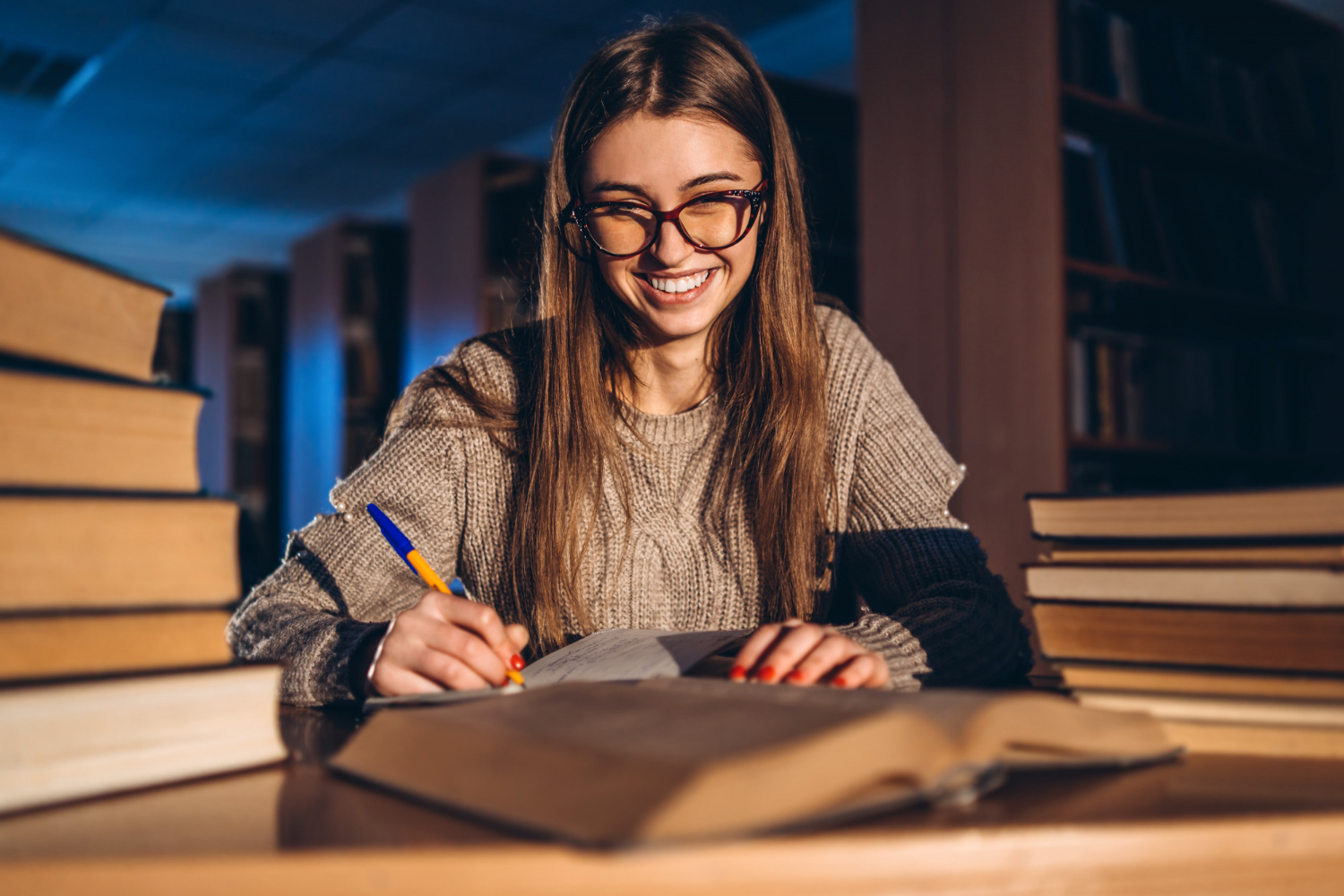 Estudante sorrindo lendo sobre tipologia textual