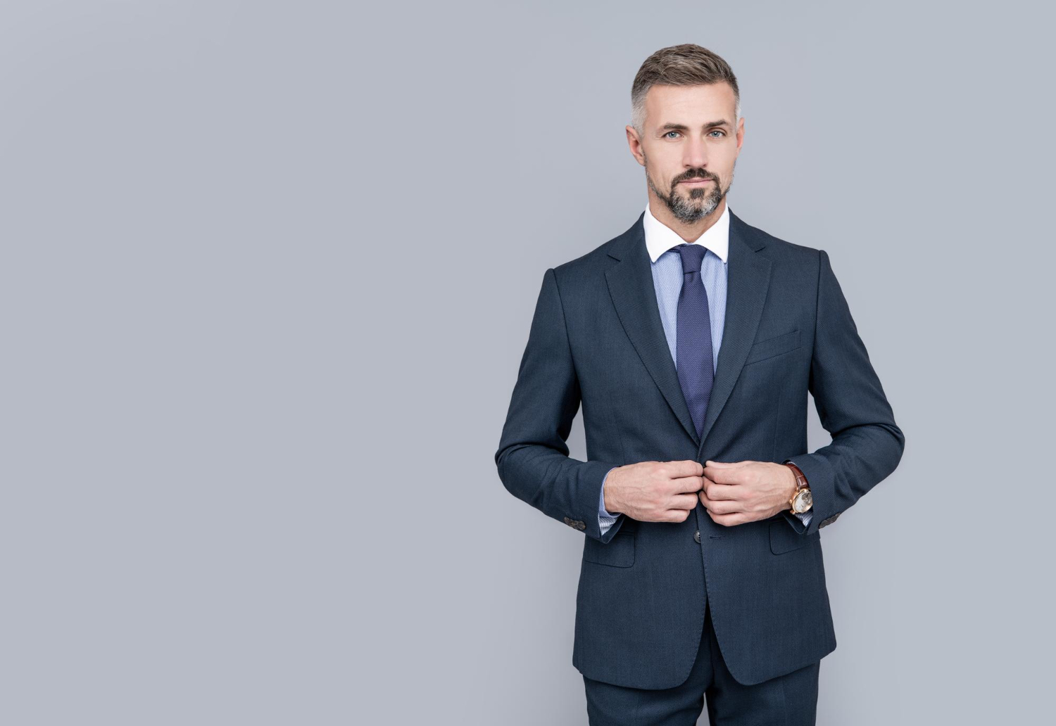 Homem de cabelo grisalho em traje formal mostrando o que faz um desembargador.
