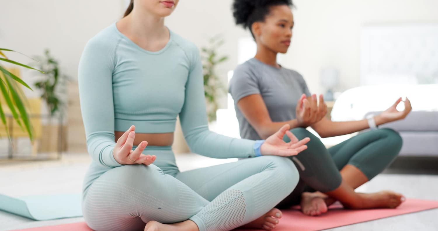 Duas mulheres aprendendo tecnicas de meditação.