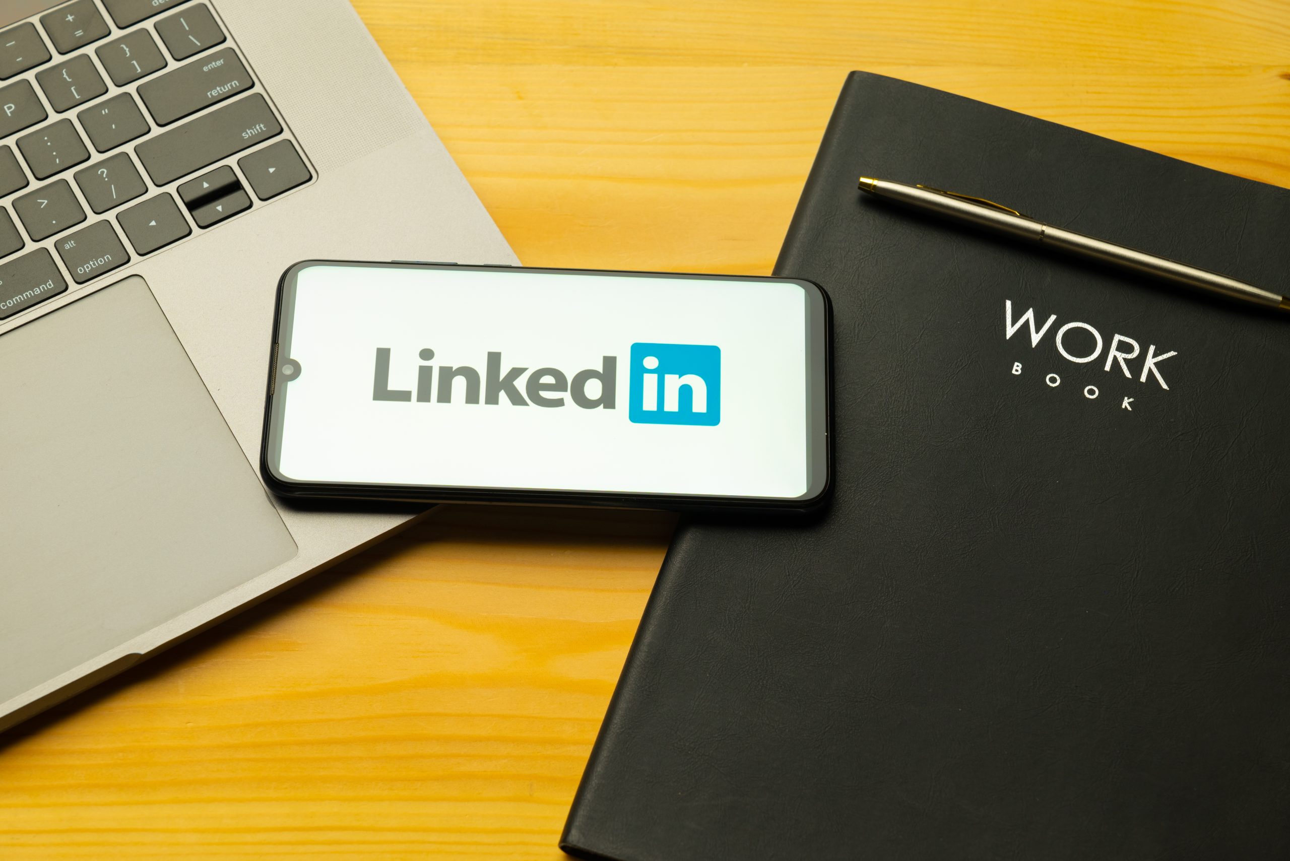 Celular em uma mesa com a logo o que é LinkedIn.