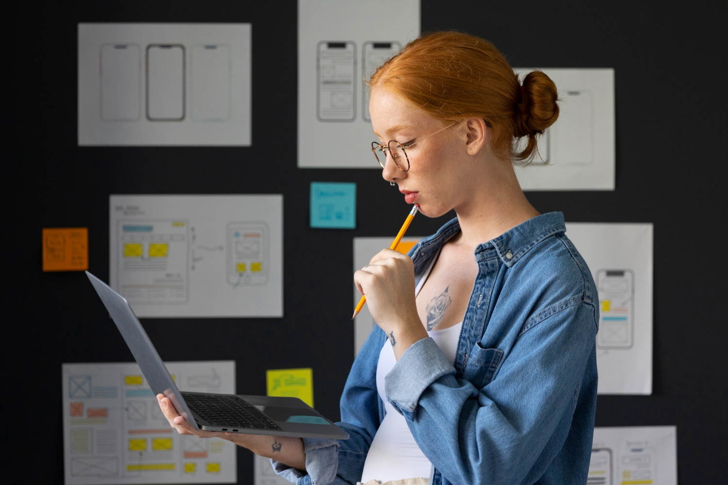 Jovem mulher em um escritório com laptop pesquisando sobre o que é um portfolio.
