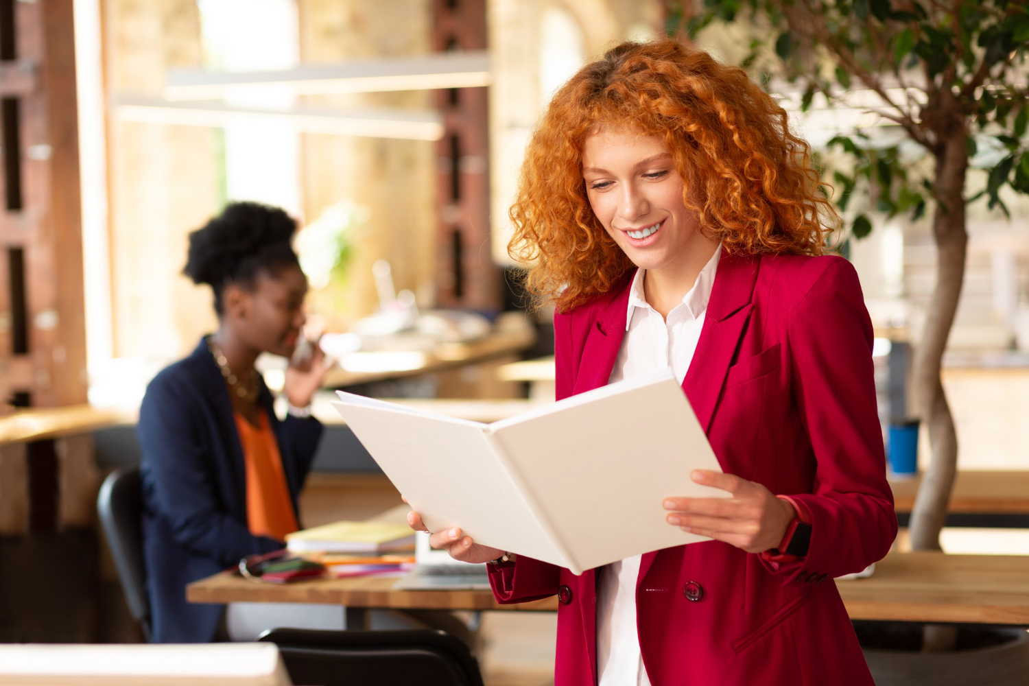Profissional sorrindo lendo sobre o plano de carreira w.